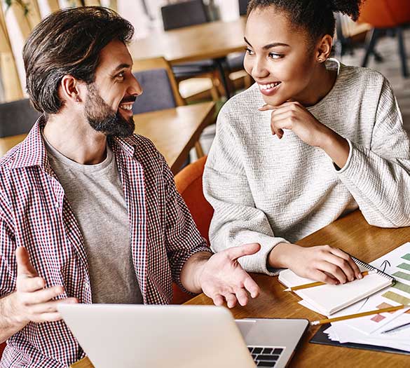 Deux collègues en train de discuter au travail sur le déploiement d'une gestion RH proactive